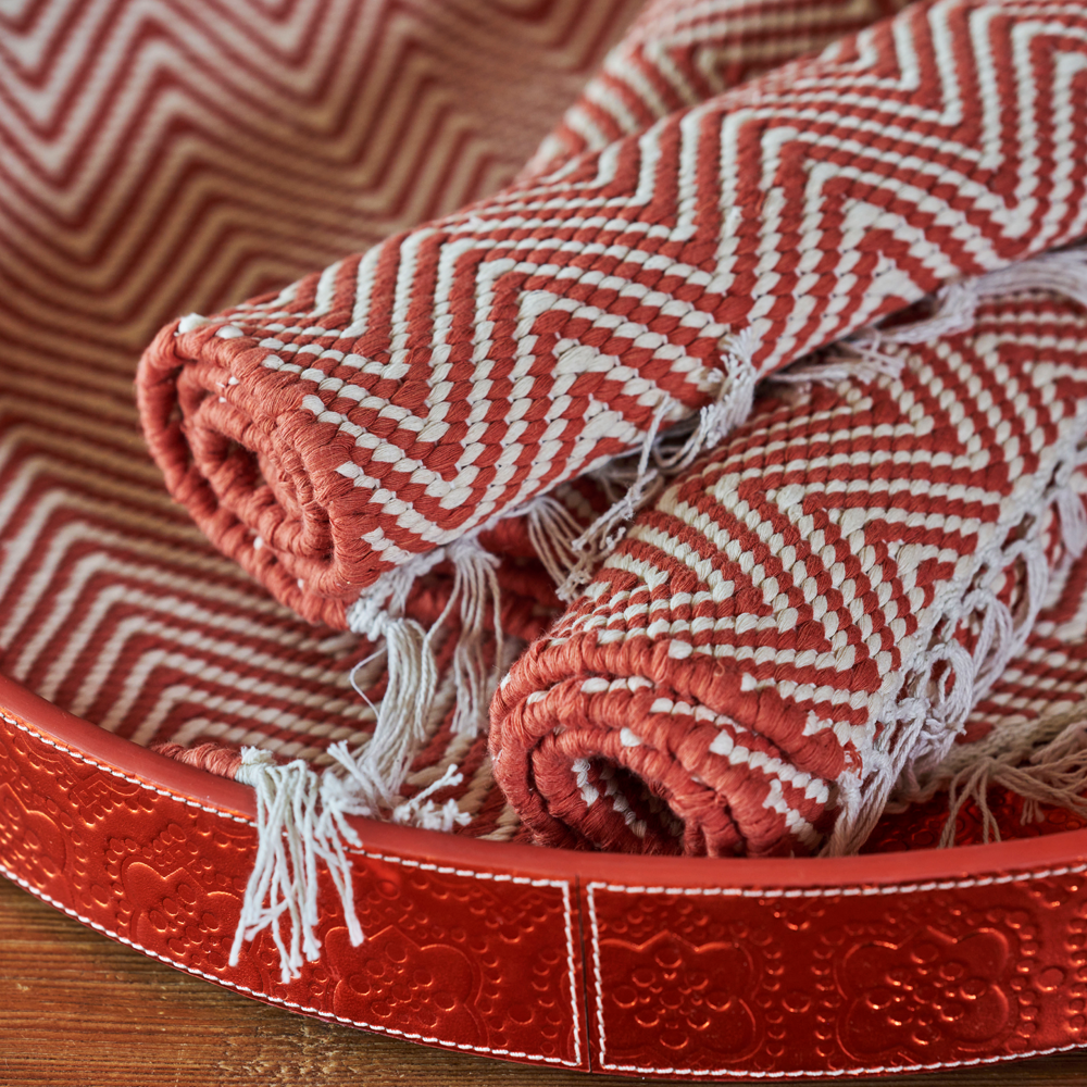 Das handgewobene Tischset wird in Rajasthan aus 100% Baumwolle gefertigt und hat auf zwei Seiten einen Fransen-Abschluss. Das Tischset ist in zwei verschiedenen Styles, Diamond und Herringbone, und in diversen Farben erhältlich. Durch sein natürliches Material kann das Produkt leichte Farbabweichungen sowie Masstoleranzen aufweisen.