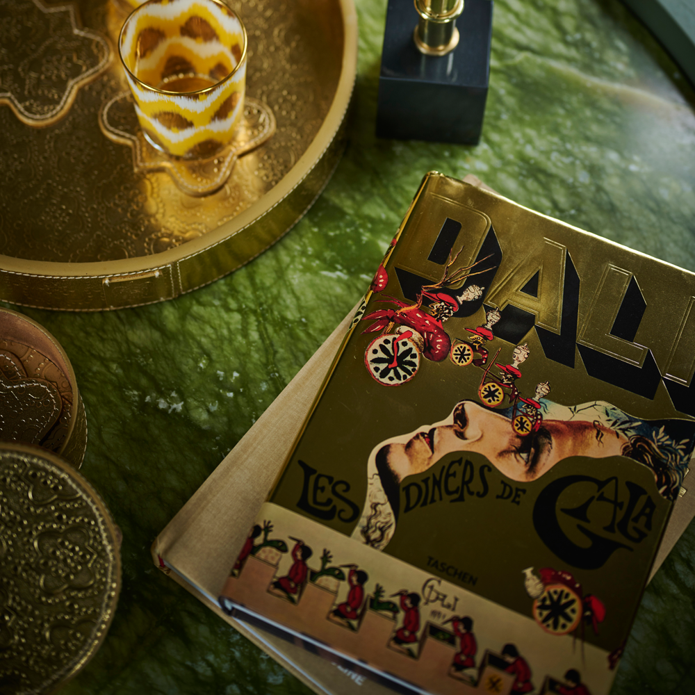 Kochbuch von Dalí Les dîners de Gala auf grünem Couchtisch