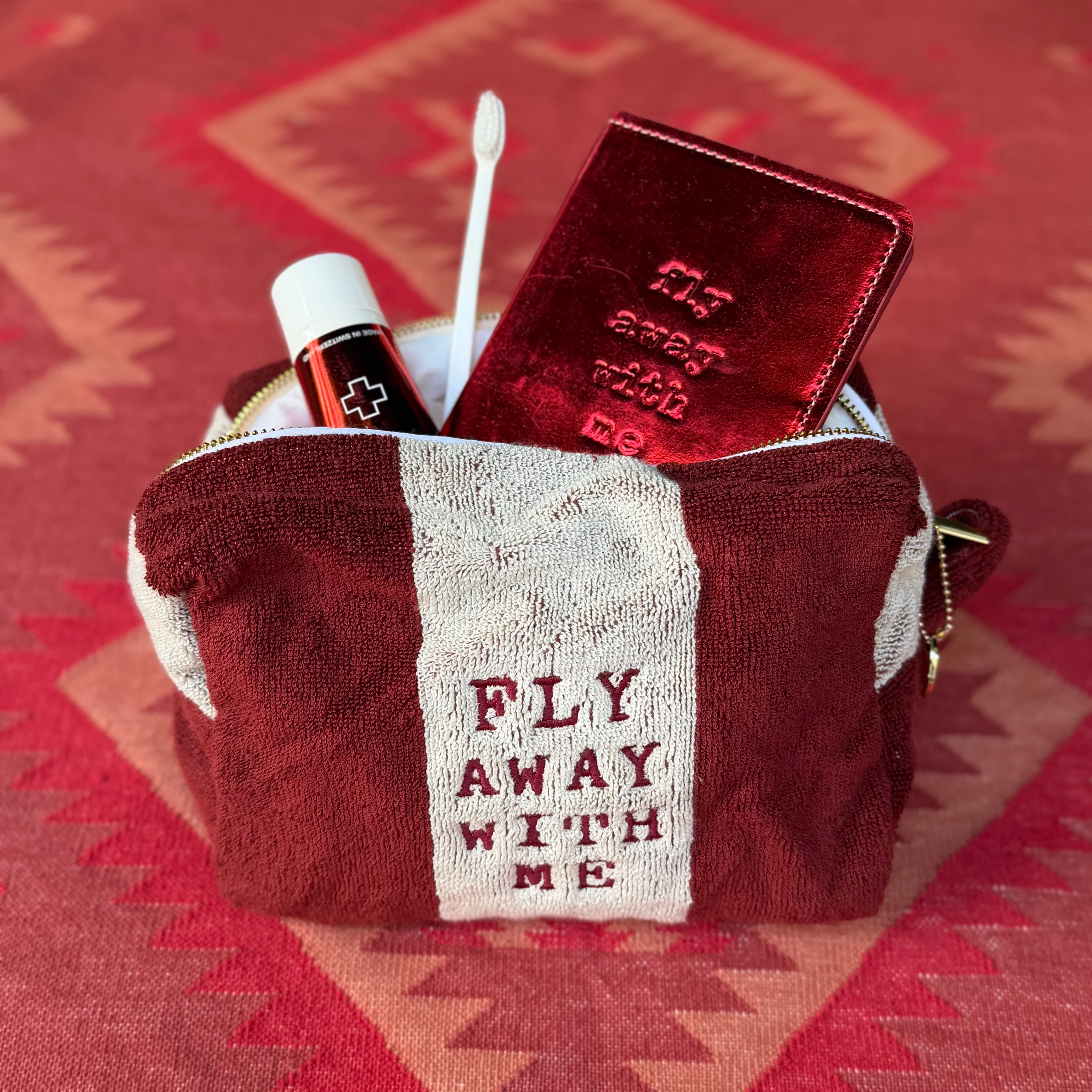 Kulturbeutel FLY AWAY WITH ME aus Frottee im Farbton dunkelrot und crème von La Serviette mit Inspiration Inhalt von Swissdent