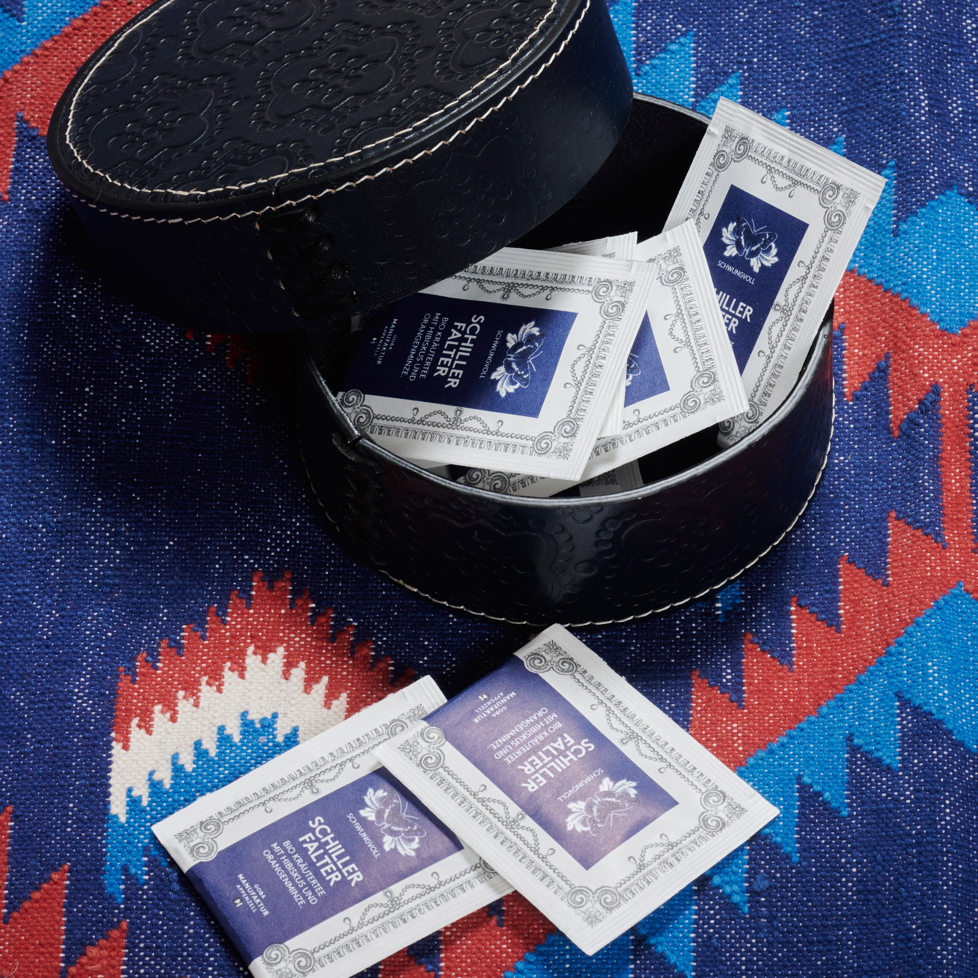 Dose rund flach ICON aus Leder geprägt in navy, gefüllt mit tee