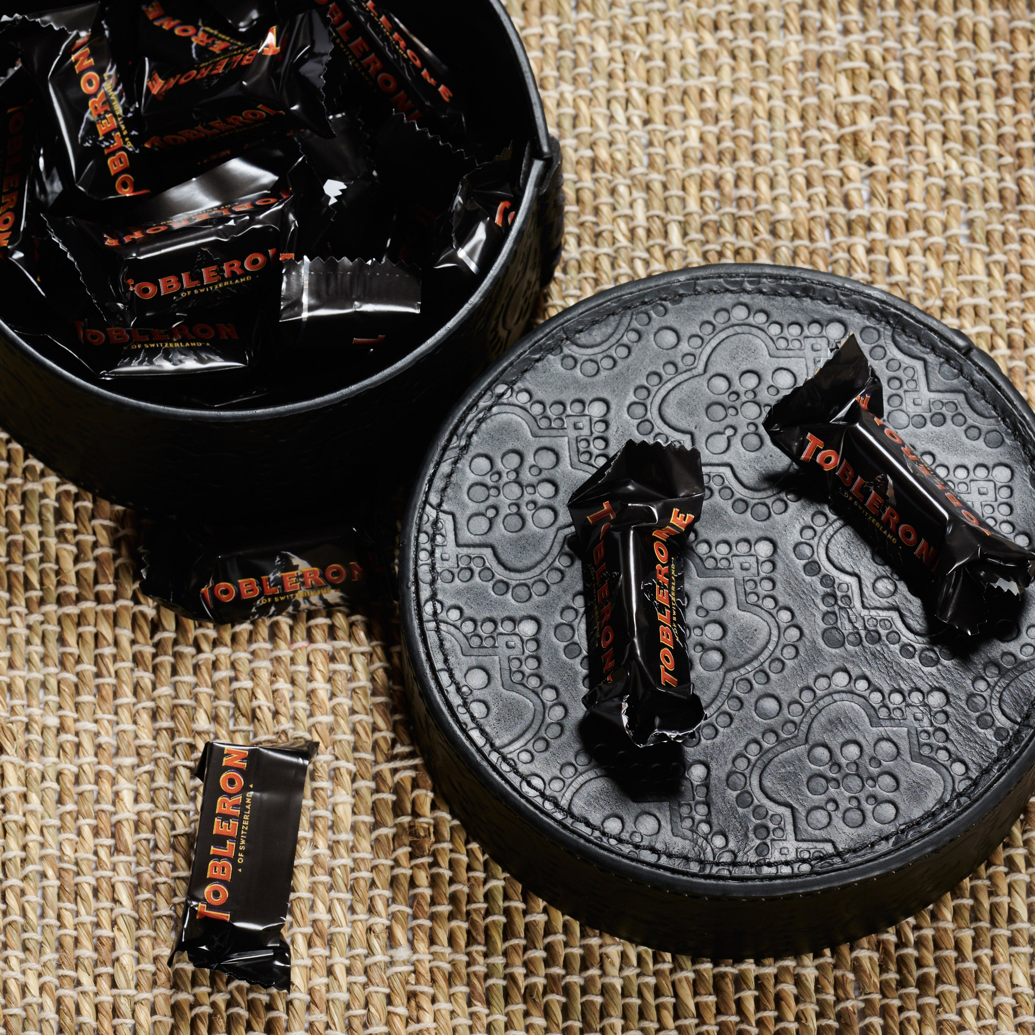 Dose rund flach ICON aus Leder geprägt in black, gefüllt mit toblerone schokolade