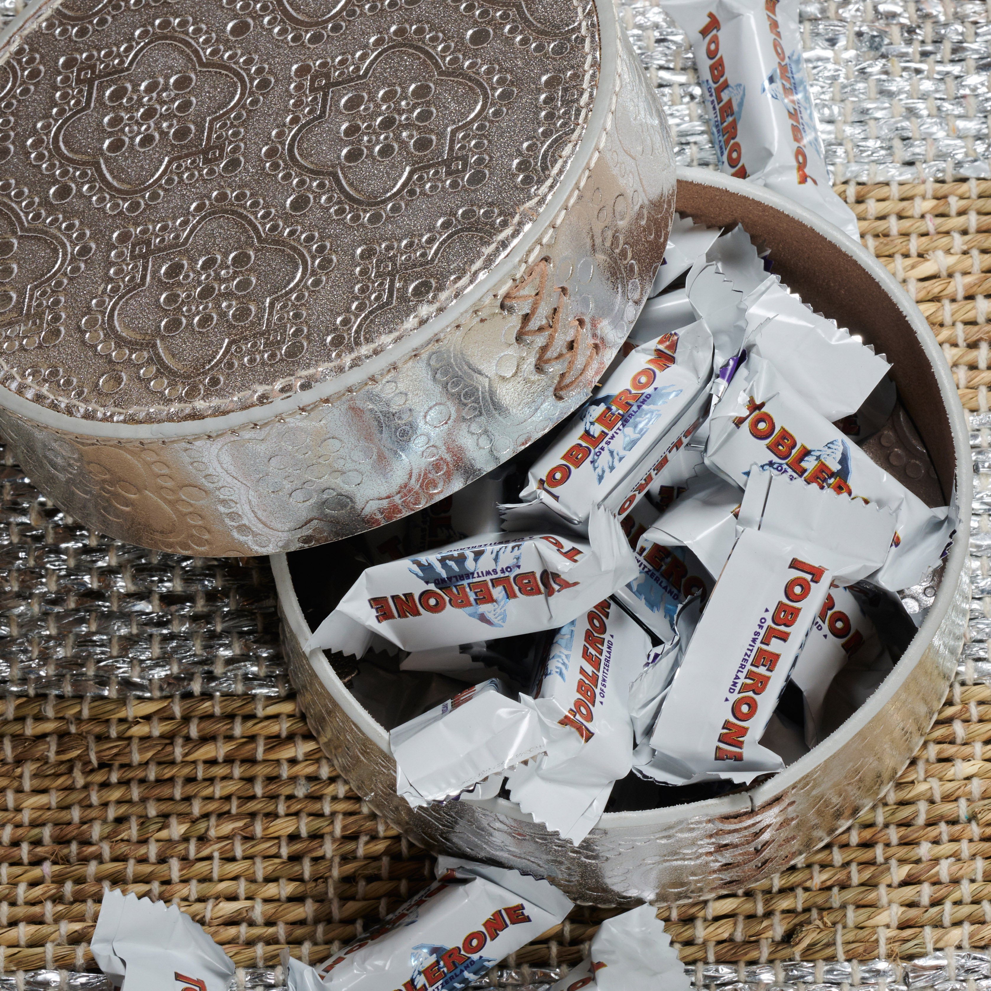 Dose rund flach ICON aus Leder geprägt in silver, gefüllt mit toblerone schokolade