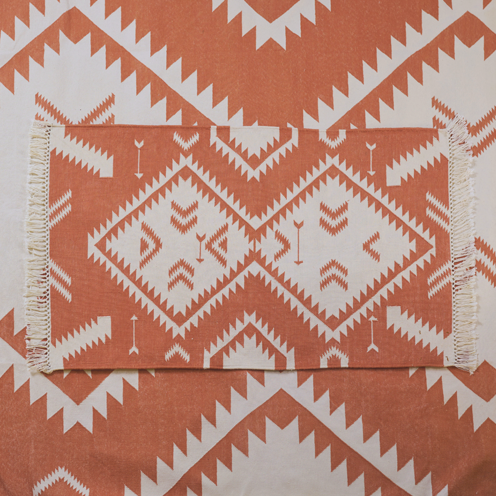Der handgewobene &#39;Dhurrie&#39; Teppich, inspiriert von der Navajo-Kultur, wird in Rajasthan gefertigt. Er ist aus 100% Baumwolle und hat auf zwei Seiten einen Fransen-Abschluss. Der Teppich ist in 2 verschiedenen Grössen und in 17 verschiedenen Farbkombinationen erhältlich. Die Teppiche können leichte Farbabweichungen sowie Masstoleranzen +/- 5cm aufweisen. Die Masse sind ohne Fransen berechnet.