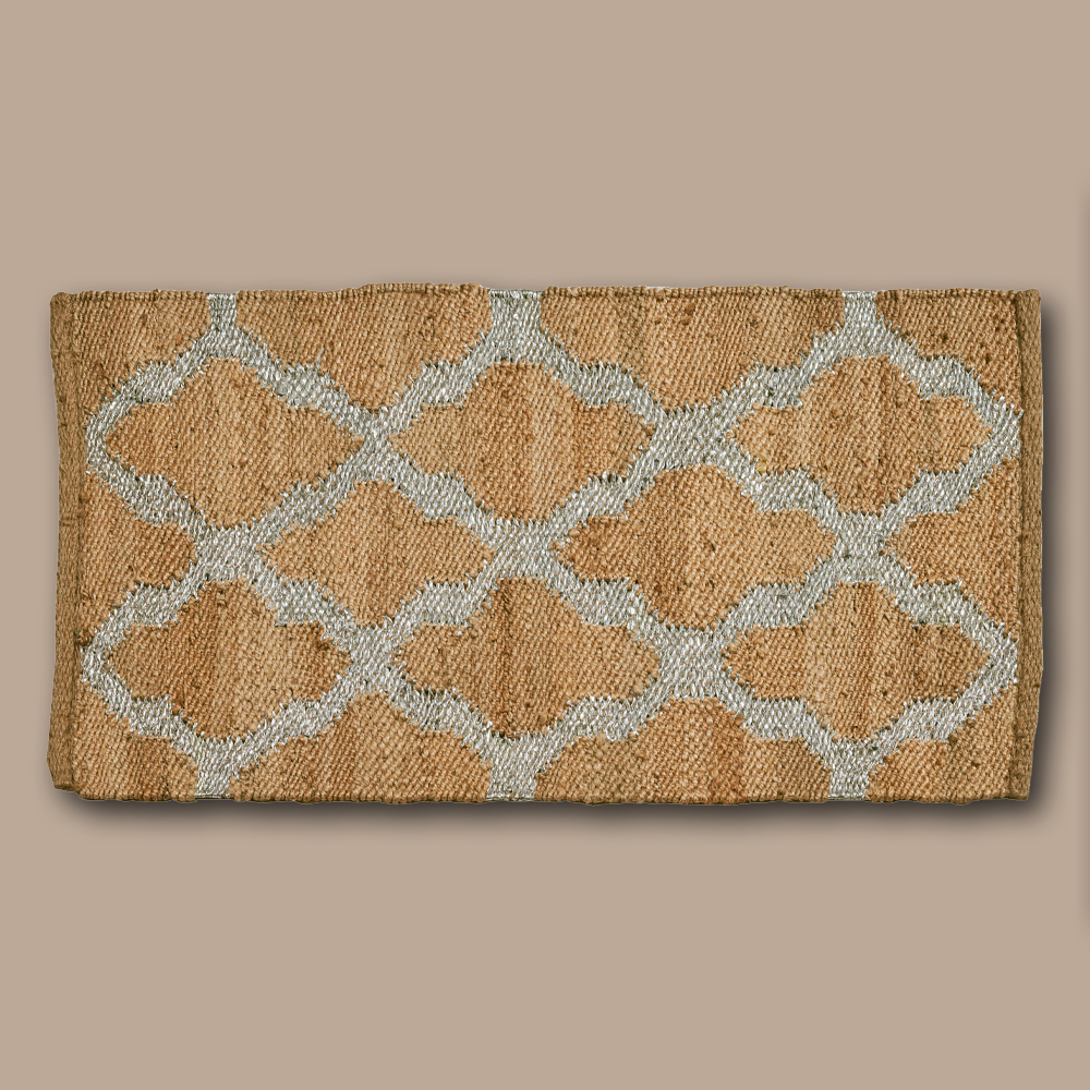 Der handgewobene Teppich wird in Rajasthan aus Jute gefertigt. Der Teppich ist in zwei verschiedenen Farben, silber und gold, erhältlich. Durch sein natürliches Material kann das Produkt leichte Farbabweichungen aufweisen.  Material: Jute