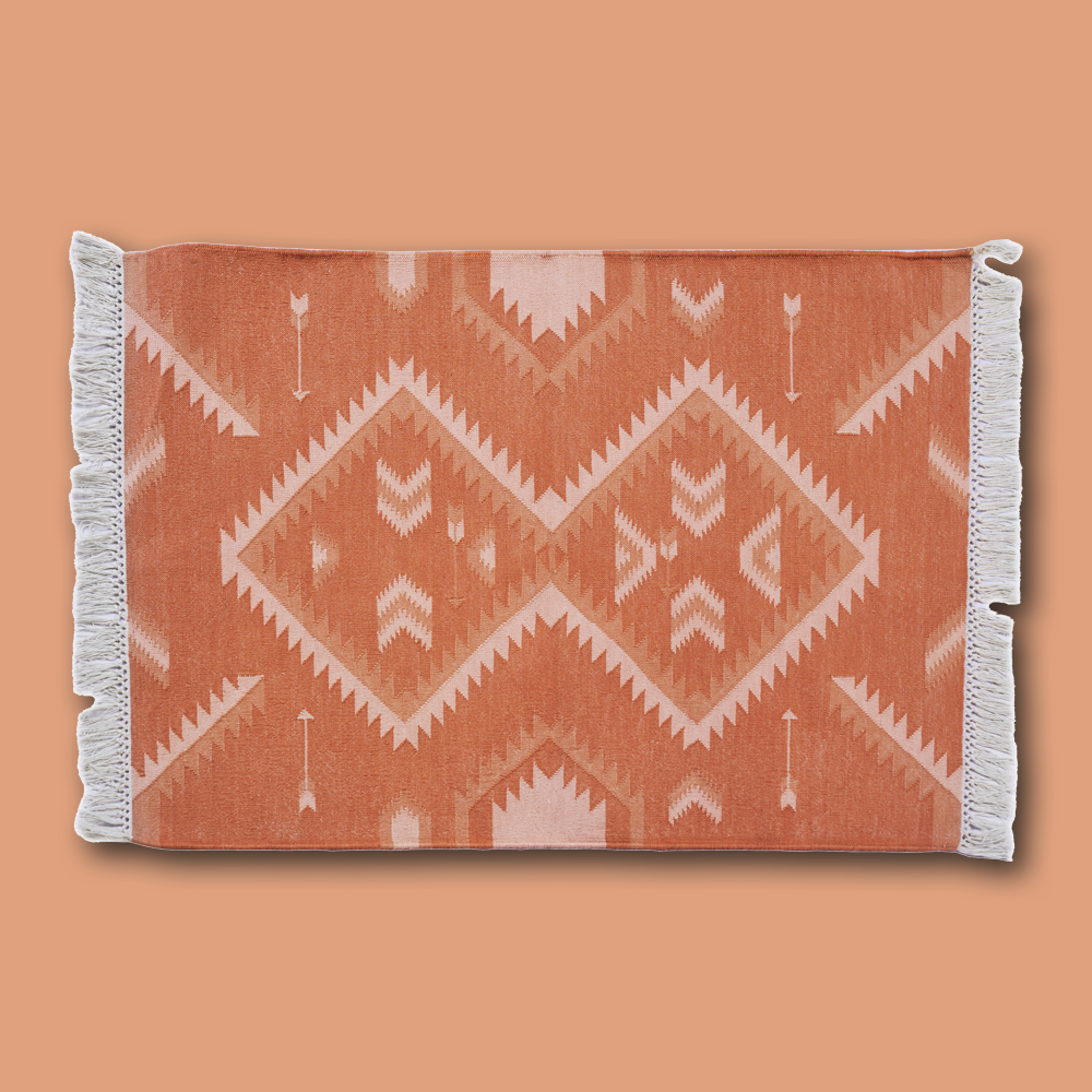 Der handgewobene &#39;Dhurrie&#39; Teppich, inspiriert von der Navajo-Kultur, wird in Rajasthan gefertigt. Er ist aus 100% Baumwolle und hat auf zwei Seiten einen Fransen-Abschluss. Der Teppich ist in 2 verschiedenen Grössen und in diversen Farbkombinationen erhältlich. Die Teppiche können leichte Farbabweichungen sowie Masstoleranzen +/- 5cm aufweisen. Die Masse sind ohne Fransen berechnet.
