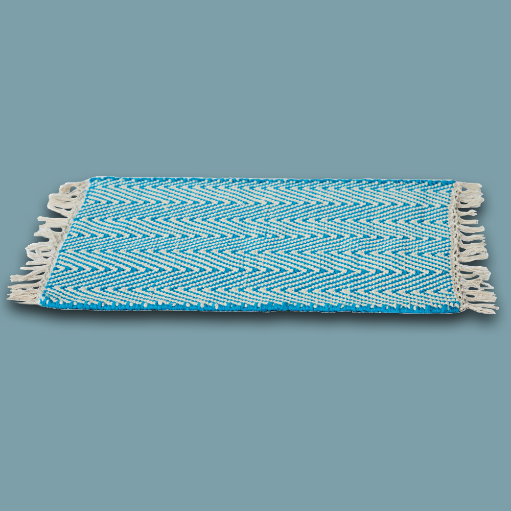 Das handgewobene Tischset wird in Rajasthan aus 100% Baumwolle gefertigt und hat auf zwei Seiten einen Fransen-Abschluss. Das Tischset ist im Herringbone Style und in diversen Farben erhältlich. Durch sein natürliches Material kann das Produkt leichte Farbabweichungen sowie Masstoleranzen aufweisen.